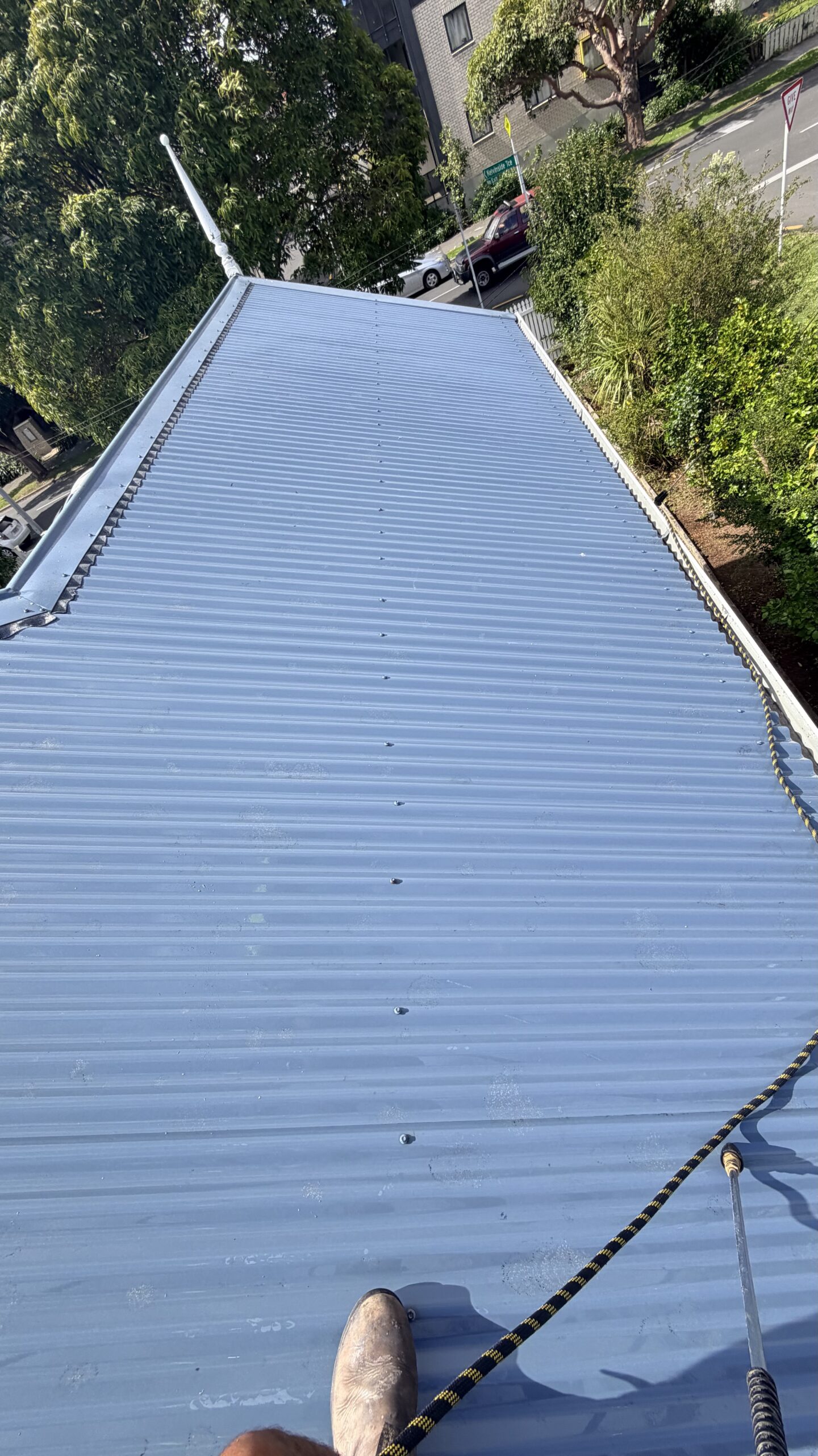 Corrugated metal roof fully cleaned and free of moss and lichen after pressure washing treatment