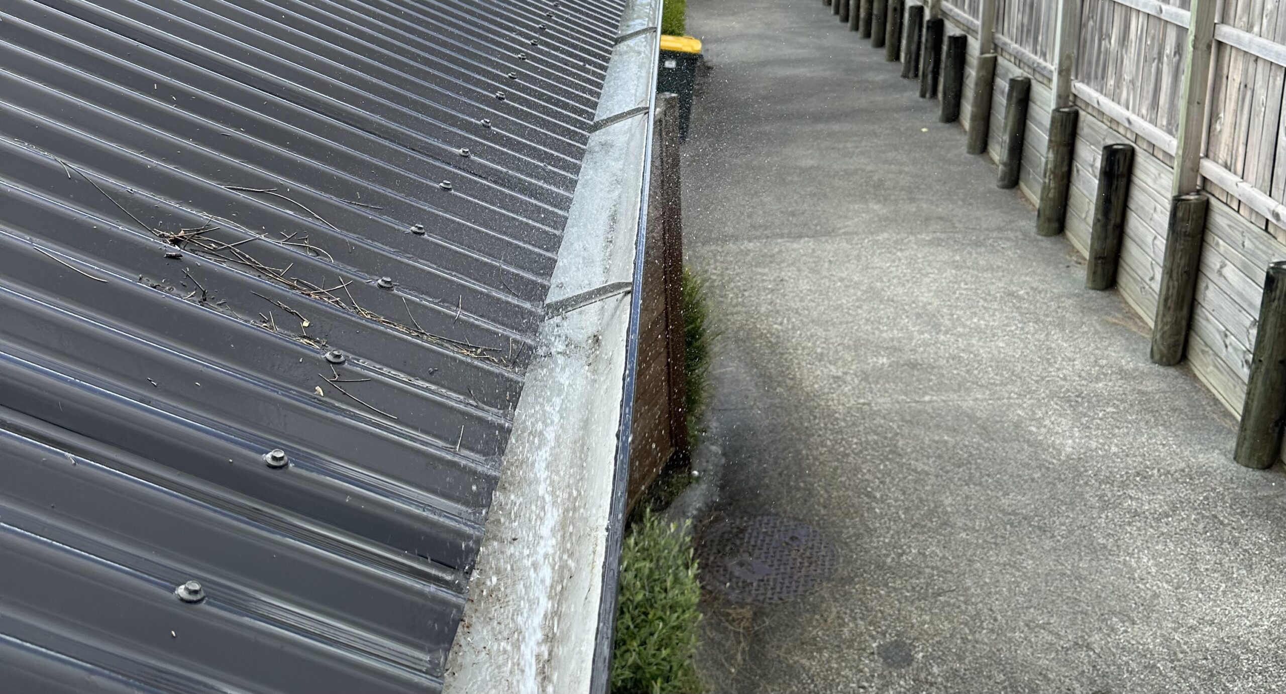 Clean, clear gutter channel being flushed with water and free-flowing drainage